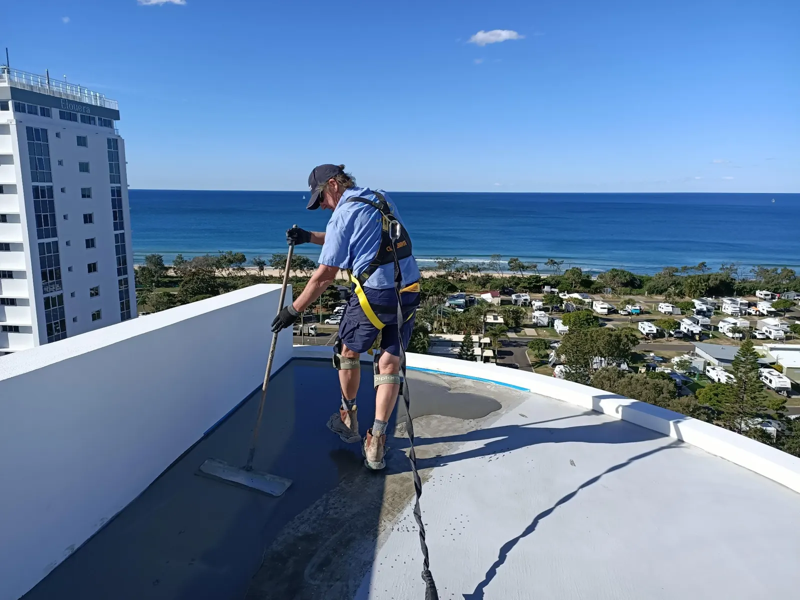Scott Cameron, founder of Floorcote, applying a coating on a Sunshine Coast rooftop project